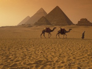 richard-nowitz-giza-pyramids-with-man-leading-two-camels-across-the-desert-in-egypt